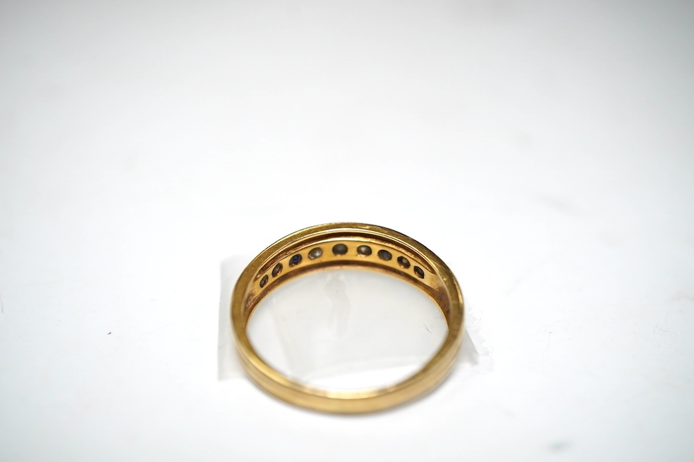 A yellow metal and channel set sapphire and diamond set half hoop ring, size Q/R, gross weight 4.2 grams. Condition - fair